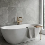 Salle de bain moderne avec baignoire îlot blanche, carrelage effet béton et robinetterie en laiton brossé